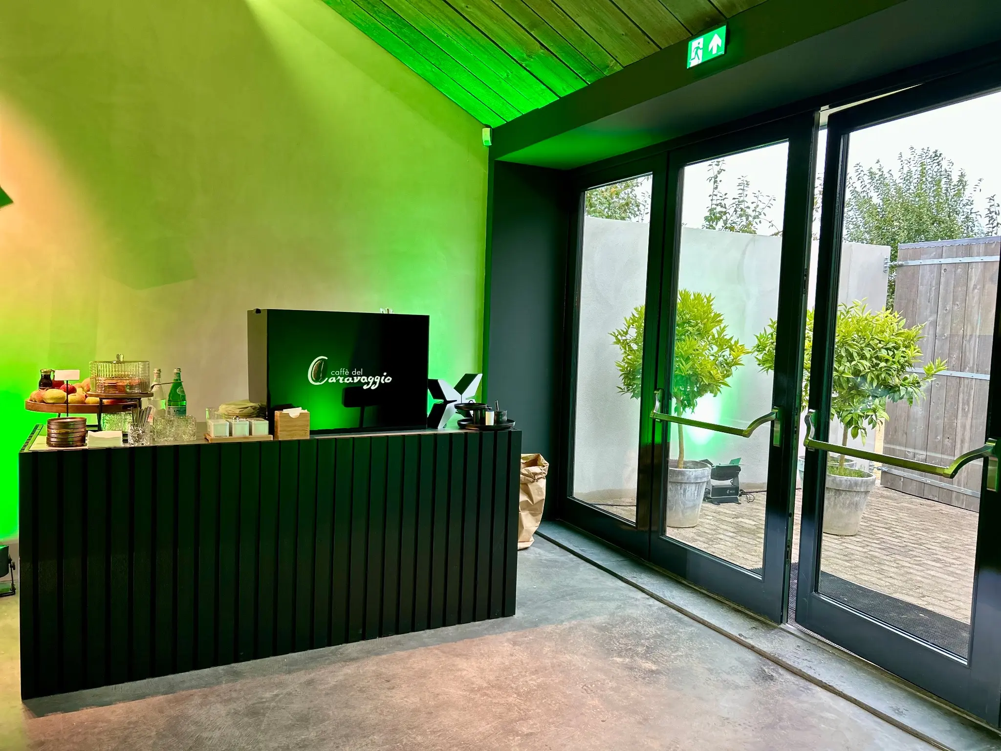 Zwarte Caffè del Caravaggio koffiebar met groene sfeerverlichting in een exclusieve eventruimte
